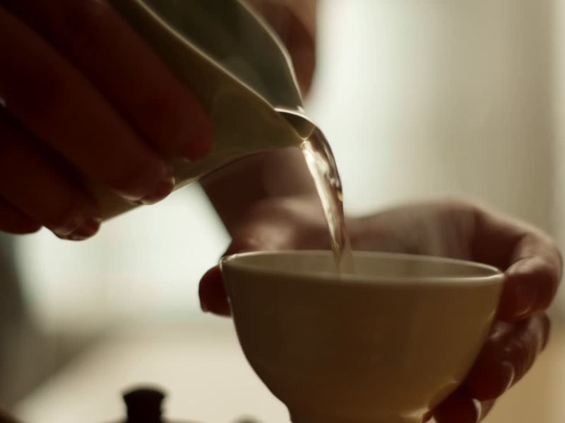 osoba sipa čaj u šoljicu