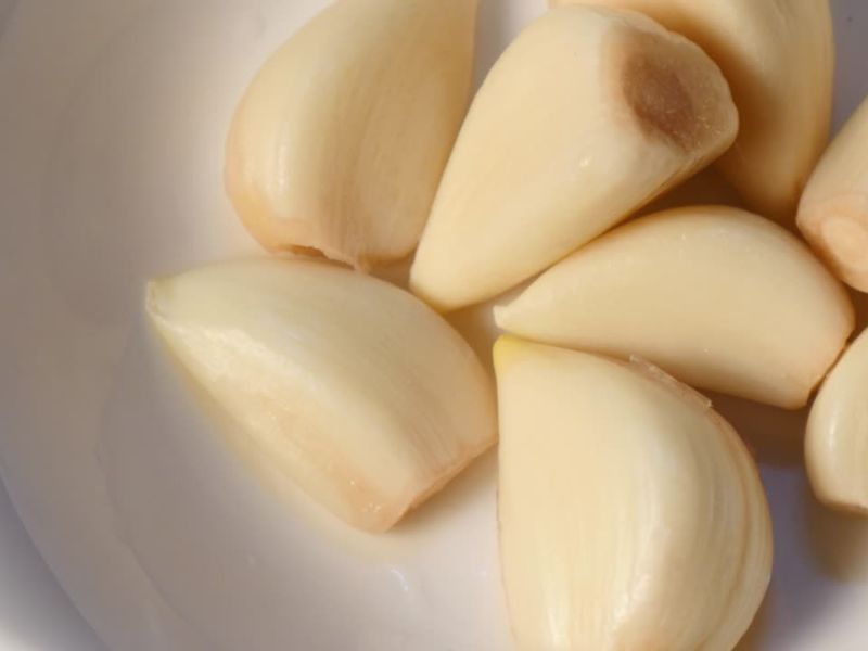 par čenova očišćenog belog luka u činiji