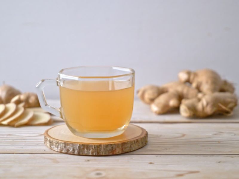 čaj od djubmria u providnoj šolji i djumbir u pozadini